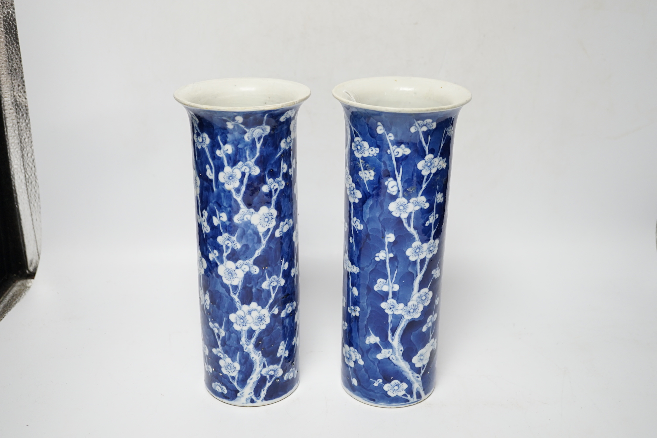 A pair of Chinese blue and white prunus flower sleeve vases, c.1900, (restored), 26cm high